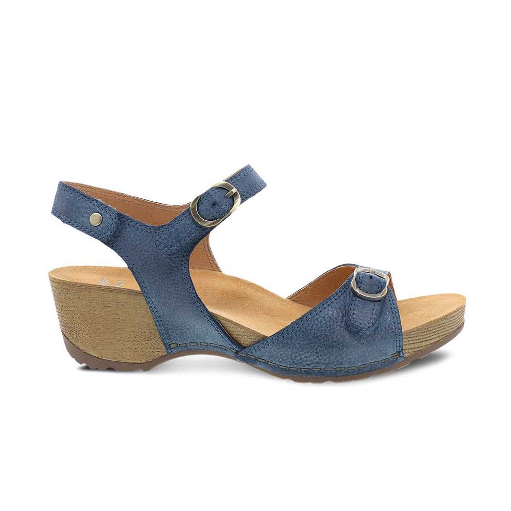 The DANSKO TRICIA BLUE - WOMEN&#39;S sandal by Dansko is a premium warm weather shoe featuring a blue hue, open-toe design, low wedge heel, ankle strap, and buckle closures on the front and ankle straps.