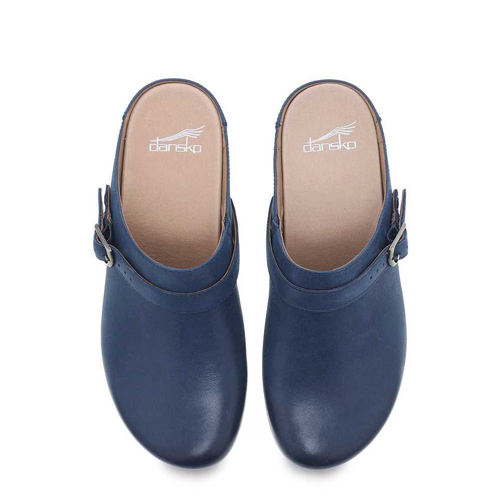 A pair of DANSKO BERRY NAVY - WOMENS clogs from Dansko, viewed from above, featuring a buckle detail on the side and nubuck uppers.