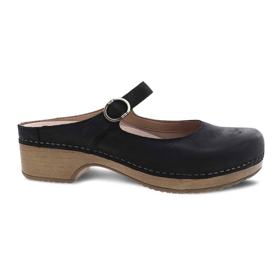 The DANSKO BRIA BLACK NUBUCK for women by Dansko is a chic Mary Jane clog featuring black nubuck leather with a wooden heel and an ankle strap secured by a metal buckle. The leather uppers are paired with a textured sole for enhanced grip, while the memory foam footbed guarantees all-day comfort.