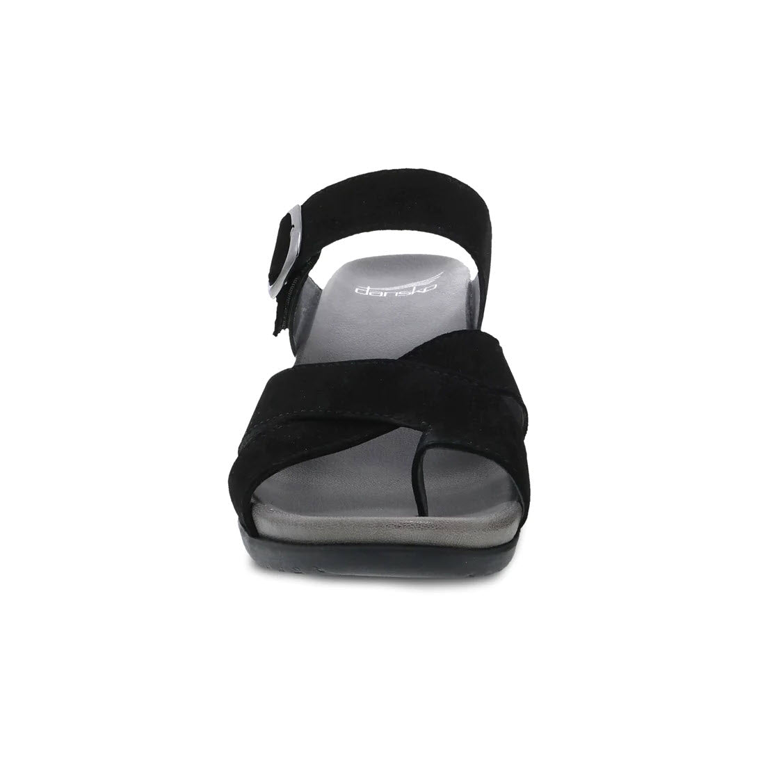 The Dansko Aubree Black Nubuck sandal for women features nubuck uppers, a thick ankle strap with buckle, a grey contoured EVA footbed, and a slight wedge heel, showcased in a forward-facing view.