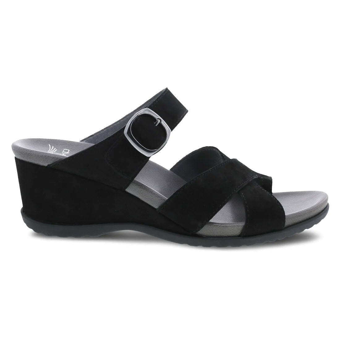 The Dansko Aubree Black Nubuck Women&#39;s sandal features nubuck uppers, an adjustable ankle strap with a silver buckle, crossing straps over the foot, and a contoured EVA footbed.