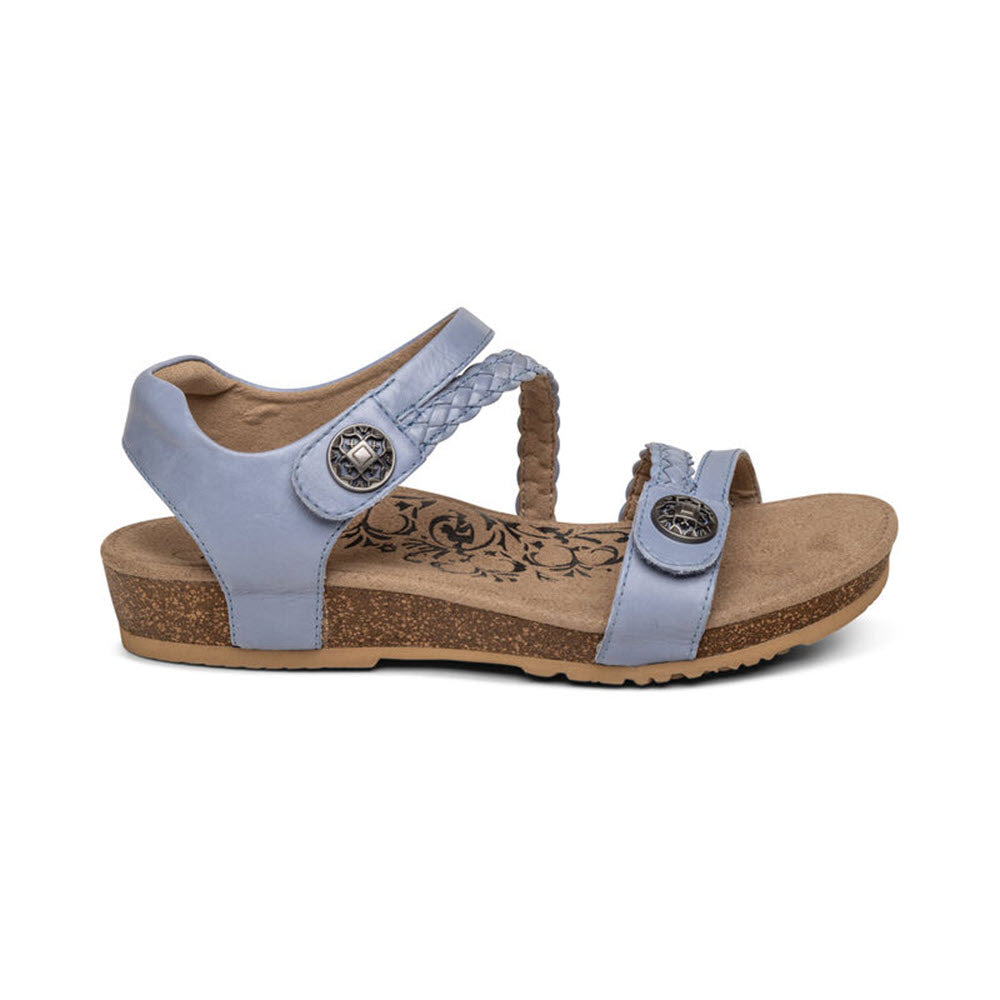 The Aetrex Jillian Blue Women's Sandal features braided straps, decorative buttons, and a floral insole set against a cork sole. It offers excellent arch support for individuals with plantar fasciitis.