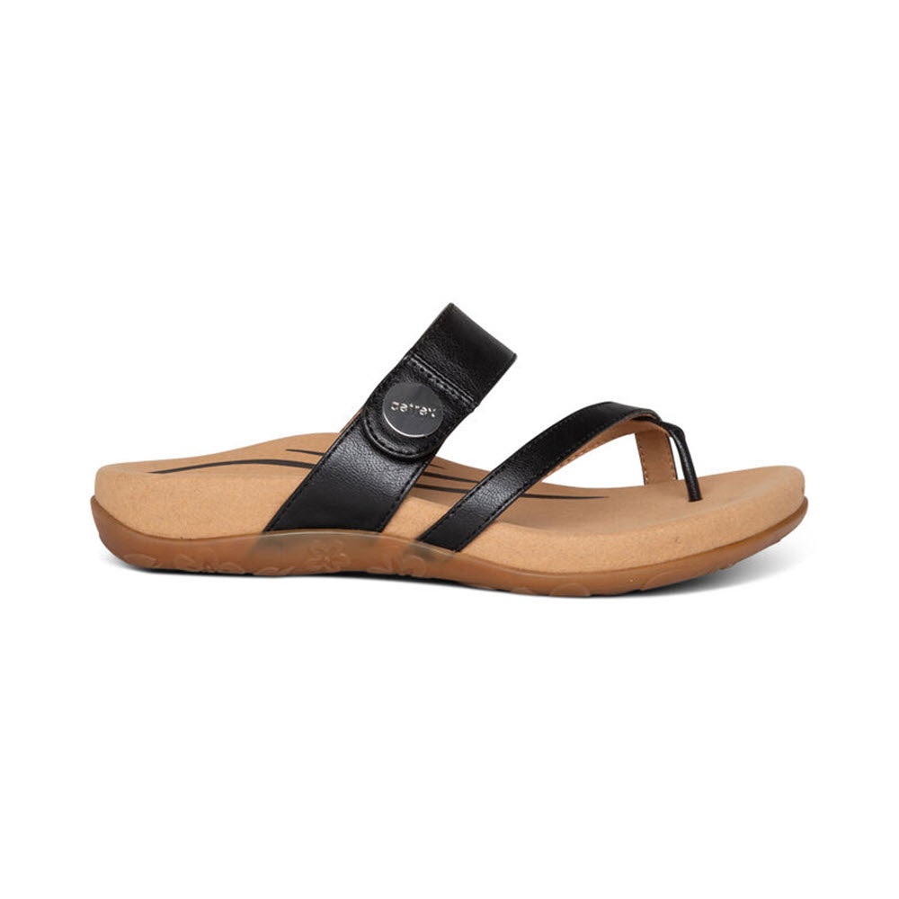 The AETREX IZZY BLACK - WOMENS sandal by Aetrex features a black leather flip-flop design with a brown cushioned sole, arch support, and a small round logo on the side strap.