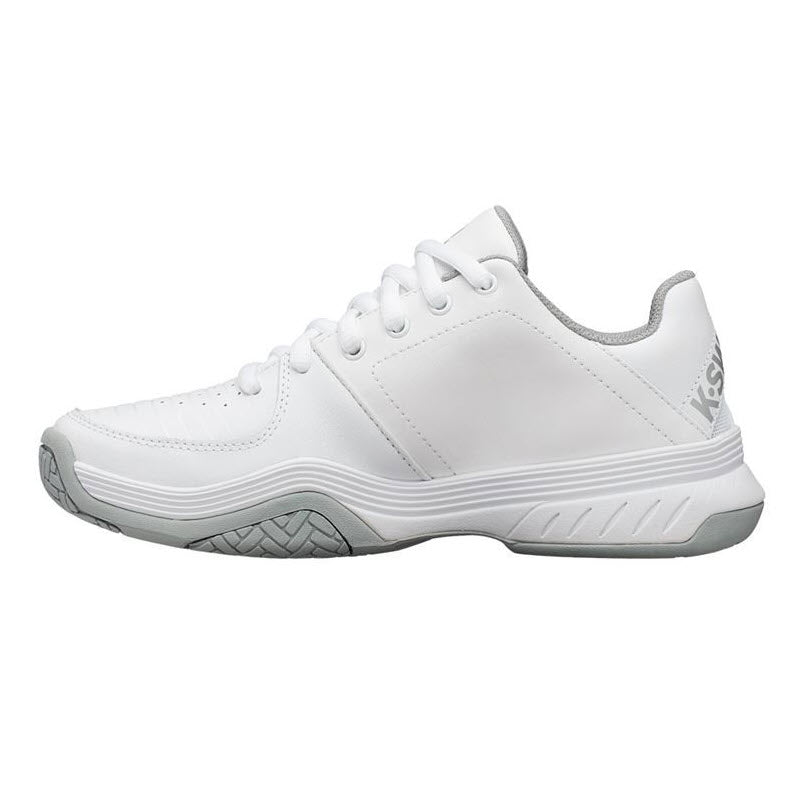 The K-Swiss Court Express White/Grey for women is an excellent entry-level tennis shoe featuring gray accents, a textured sole, and a lace-up design. This white athletic sneaker offers comfortable support and showcases the K-Swiss branding on the back heel.