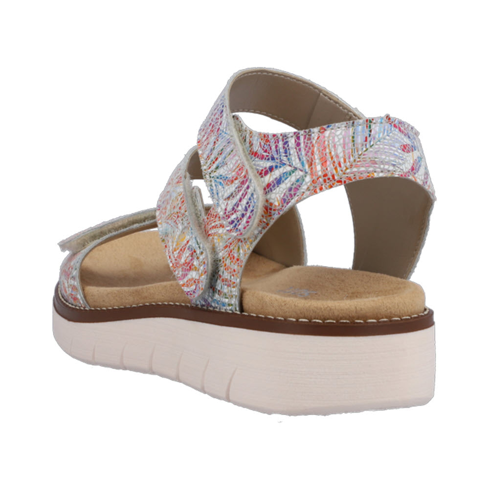 Back view of the REMONTE ASYMMETRICAL SANDAL FLORAL MULTI - WOMENS by Remonte, featuring a comfortable multicolored design with a thick white sole, beige insole, and Velcro straps.