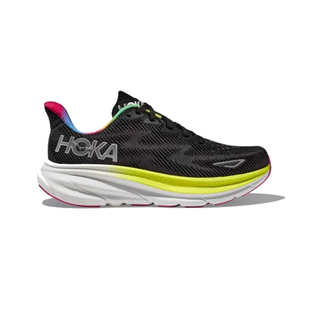 The Hoka Clifton 9 Black/All Aboard women's running shoe features "HOKA" written on the side and a distinctive thick, white sole with yellow, pink, and green accents. These cushioned running shoes offer responsive foam for enhanced comfort and performance.