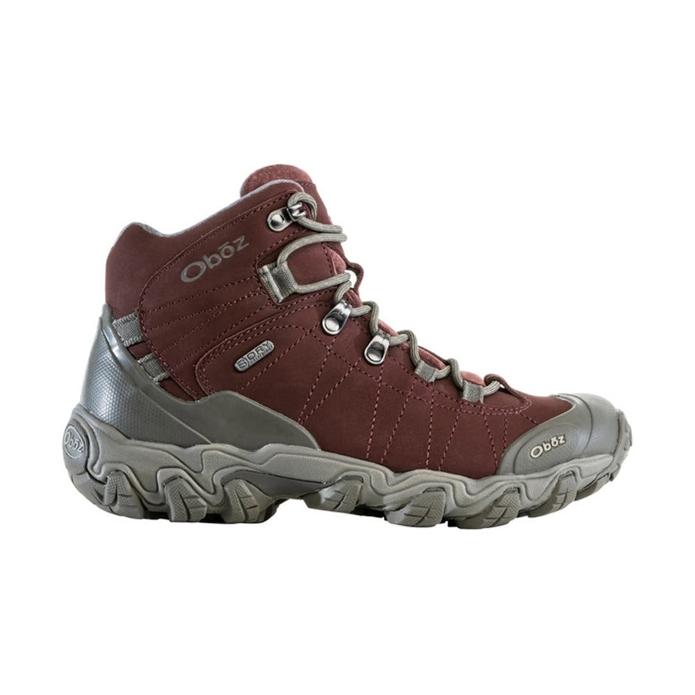 A maroon and gray OBOZ BRIDGER MID B-DRY PORT - WOMENS with the brand name Oboz on the side, featuring a rugged sole and lace-up closure for exceptional trail performance and durability.