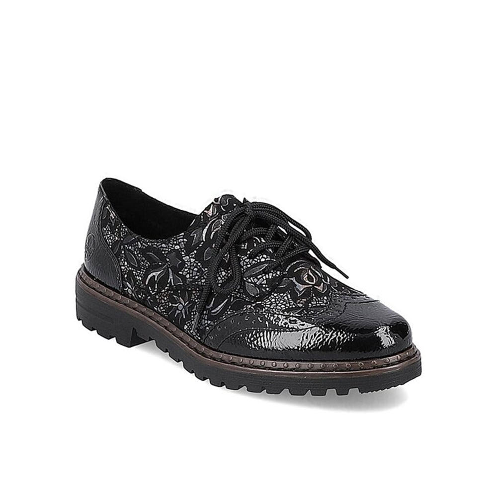 The RIEKER MODERN TAILORED BROGUE BLACK META - WOMENS by Rieker is a black lace-up shoe with a low heel and textured sole, featuring a glossy finish and floral patterned brogue design.