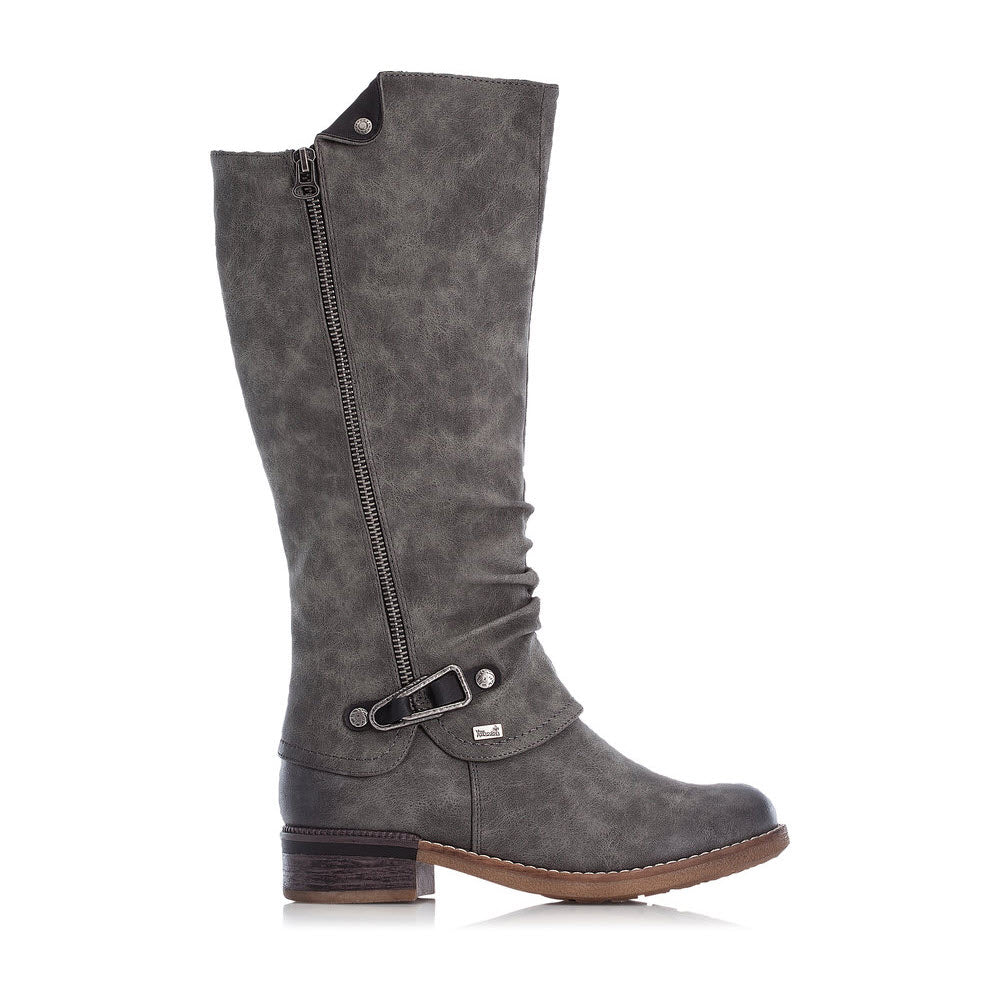 The Rieker RIEKER RIDING BOOT WITH BUCKLE SMOKE - WOMENS are knee-high, dark gray boots featuring a decorative zipper on the side, a buckle strap at the ankle, and a low stacked heel. These boots are water resistant with a cozy lambswool lining for extra warmth and comfort.
