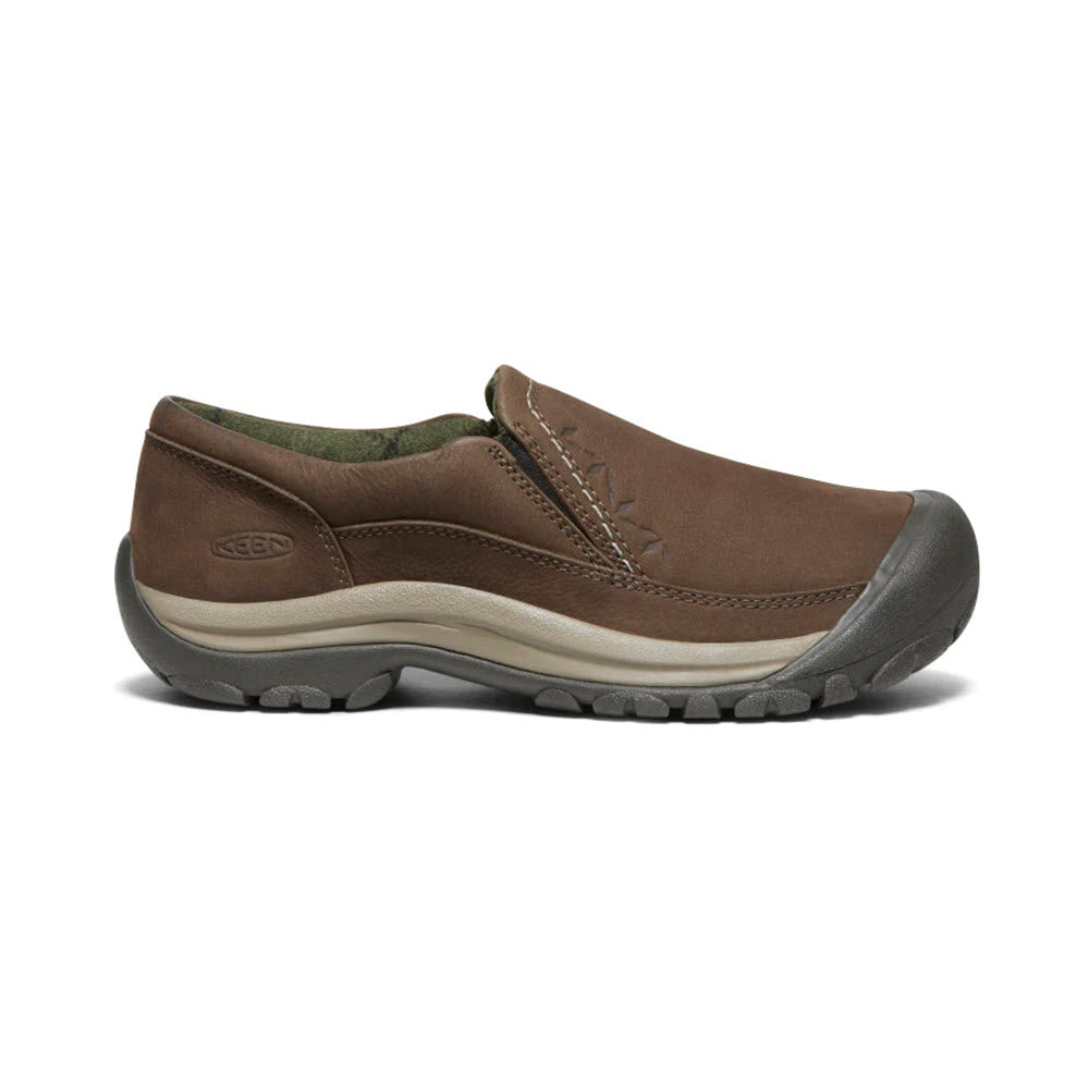 The KEEN KACI III WINTER DARK EARTH for women is a brown winter slip-on shoe, featuring a rugged sole and rubber toe cap, shown from the side. It offers warmth and waterproofing for those cold, wet days.