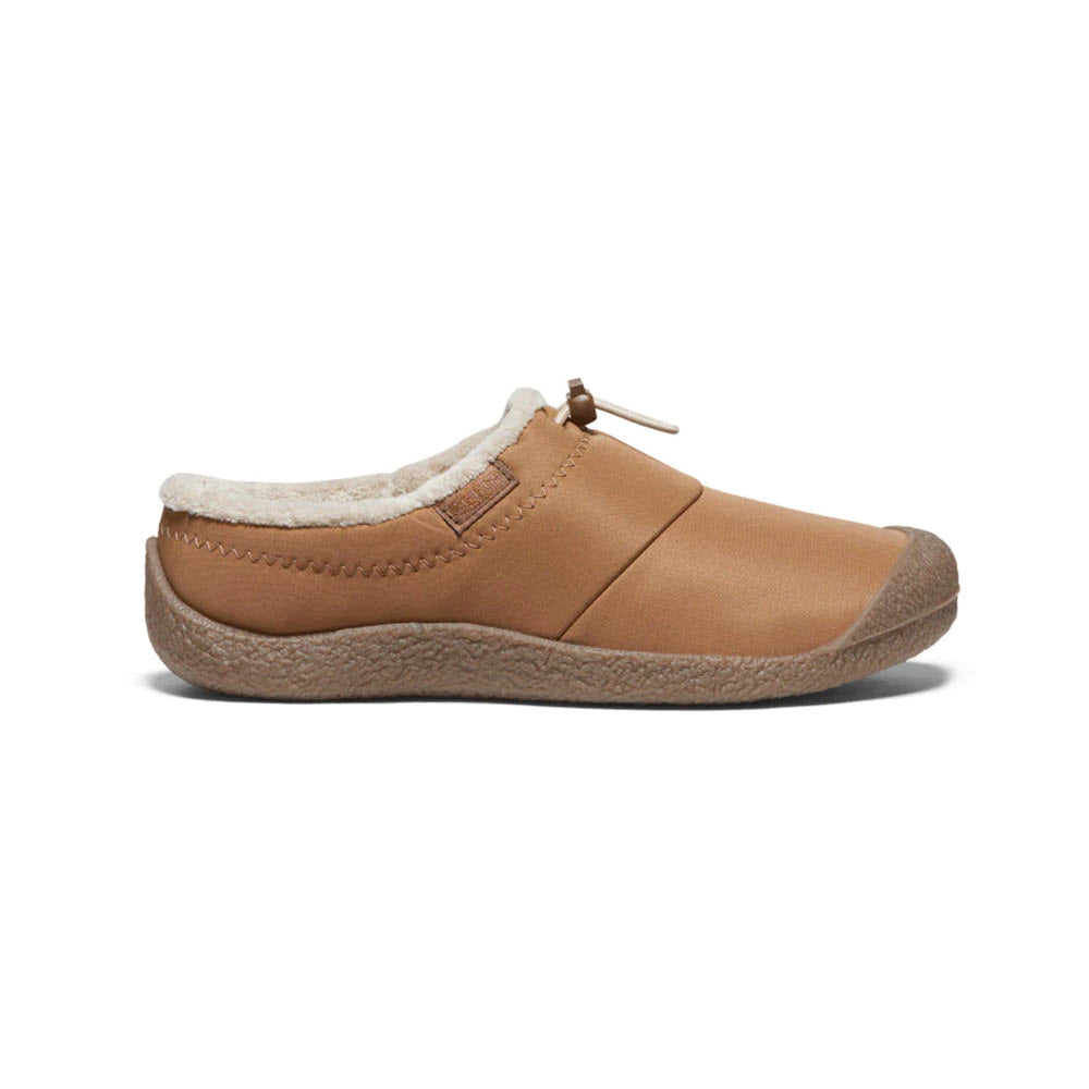 Side view of the KEEN HOWSER III TOASTED COCONUT for women, a brown slip-on shoe by Keen featuring a textured rubber sole for traction, plush fur-like lining, and a bungee drawstring closure at the top.