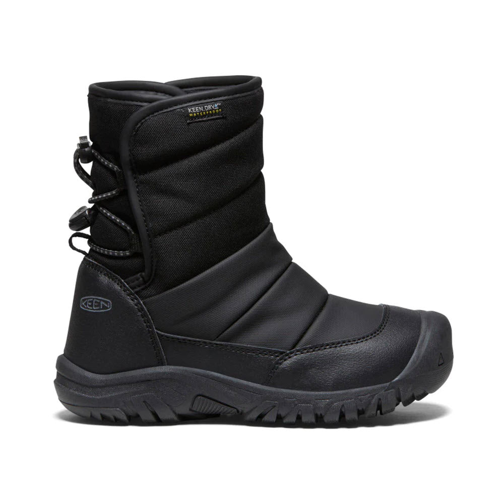 A black, insulated winter boot with a rugged sole, high-top design, and lace-up back. The waterproof KEEN PUFFRIDER BLACK - KIDS snow boot from Keen features a bungee-cinch opening for easy wear. The branding "KEEN" is visible.