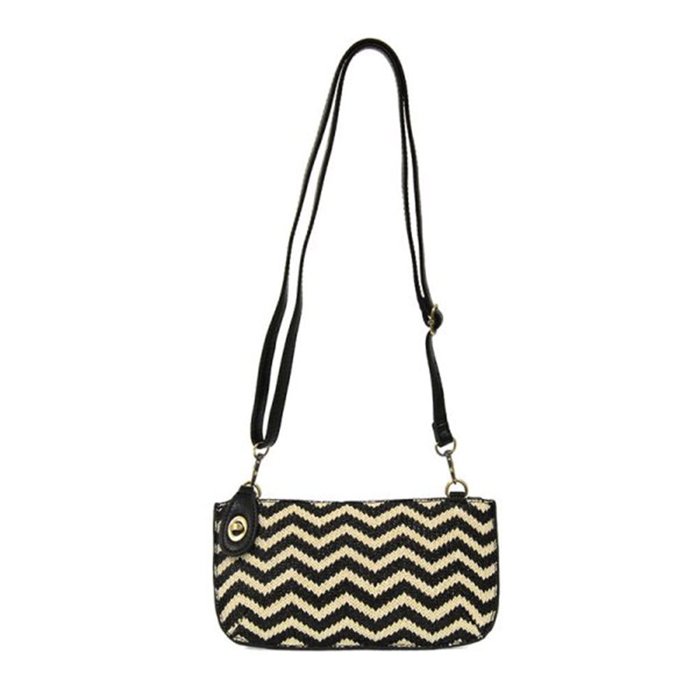 The Joy Susan JOY SUSAN STRAW MINI CROSSBODY WRISTLET BLACK/CREAM is a small rectangular shoulder bag with a black and beige zigzag pattern, black straps, and convenient credit card pockets—perfect for those who prefer to travel light.