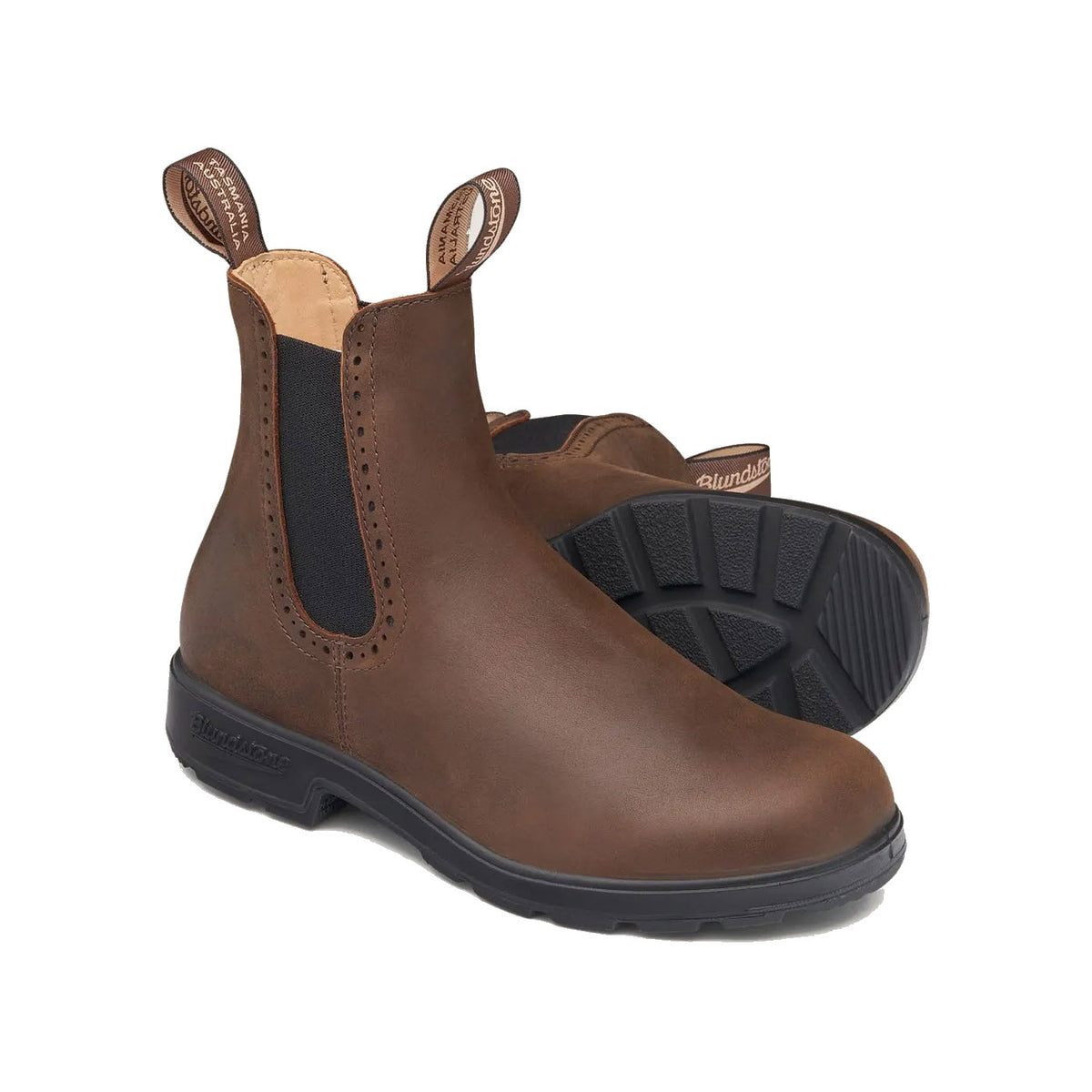 A pair of Blundstone BLUNDSTONE 2151 HIGH TOP ANTIQUE BROWN - WOMENS boots with black elastic side panels and black soles. One high-top boot is upright, while the other lies on its side, showcasing their comfort and durability.