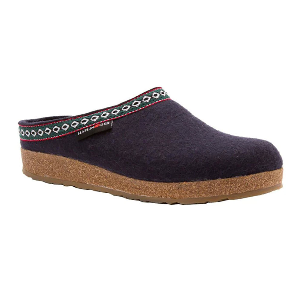 The Haflingers HAFLINGER GZ NAVY - WOMENS features a dark wool upper, patterned trim, and a cork sole, all crafted with an anatomically correct footbed for superior comfort.