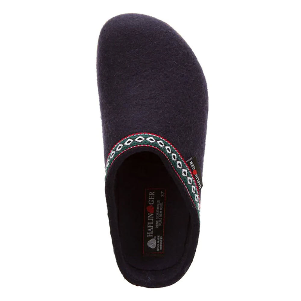 A single dark-colored slip-on slipper with embroidered decorative trim around the opening, featuring an anatomically correct footbed and a visible inner label, embodying the German casual style of the Haflingers HAFLINGER GZ NAVY - WOMENS.