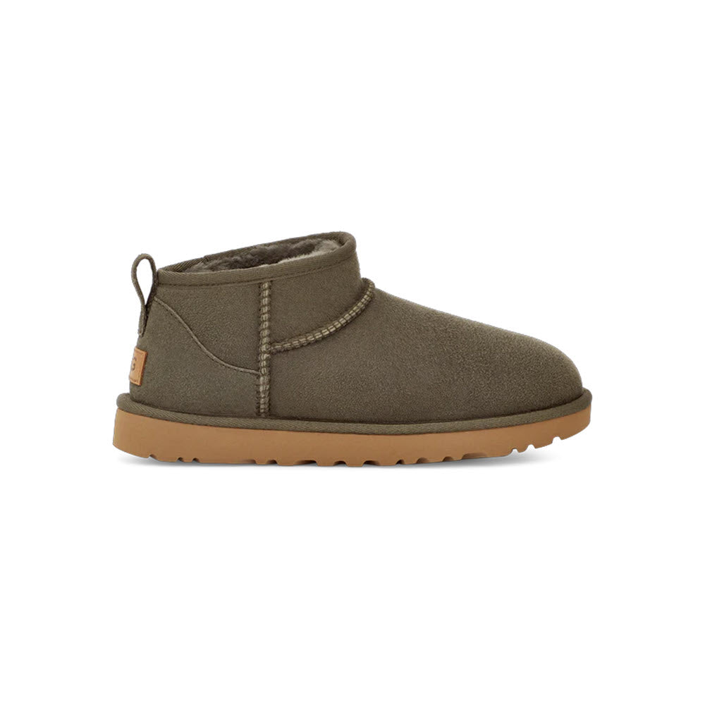 A single UGG CLASSIC ULTRA MINI FOREST NIGHT - WOMENS by Ugg with a brown rubber sole, featuring a cozy sheepskin insole and a pull tab at the back.