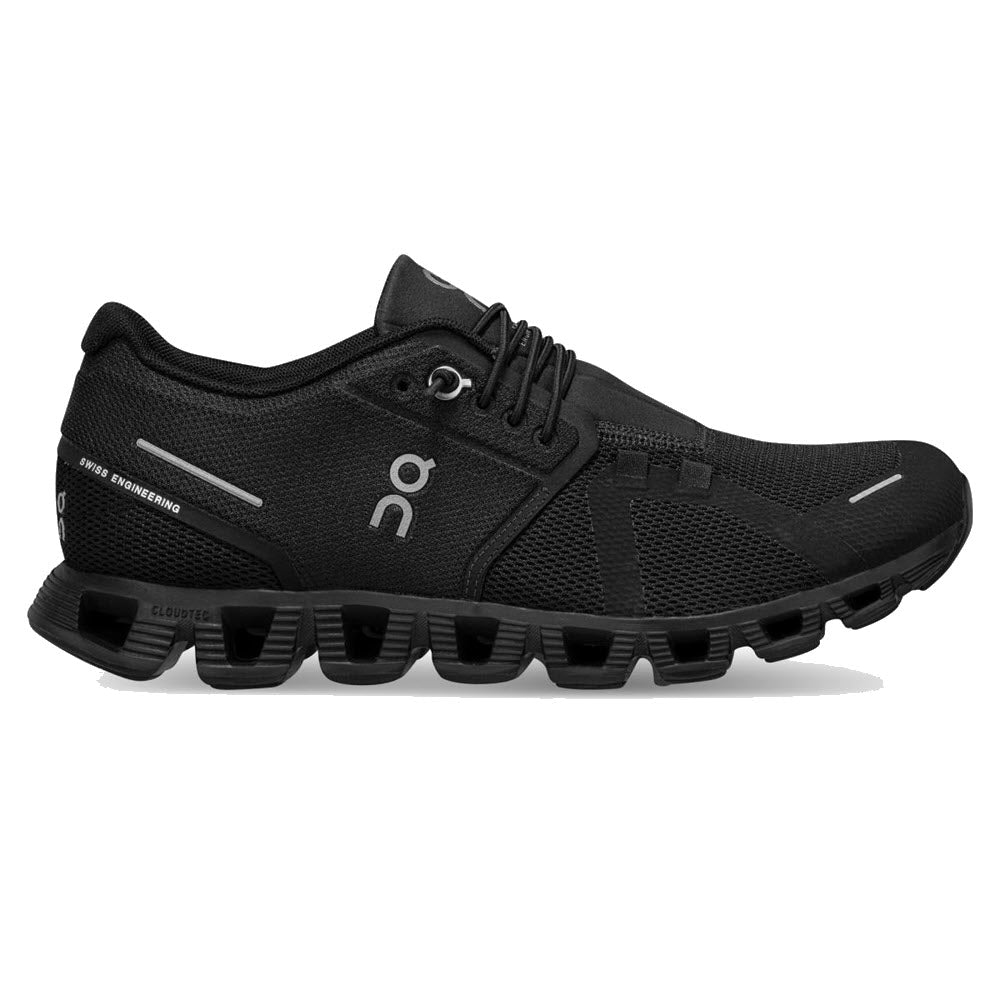 A black athletic shoe with unique hollowed soles, branded with the letters &quot;ON&quot; on the side. The ON RUNNING CLOUD 5 ALL BLACK - WOMENS from On Running features a mesh upper and a lace-up design for an improved fit, offering more comfort for all day wear.