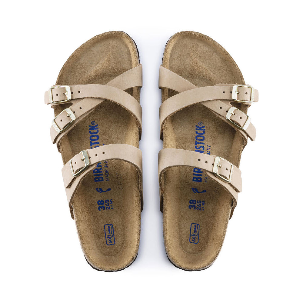 A pair of Birkenstock BIRKENSTOCK FRANCA SANDCASTLE NUBUCK - WOMENS sandals with stylish crisscrossed straps made from nubuck leather and three buckles on each foot, shown from above.