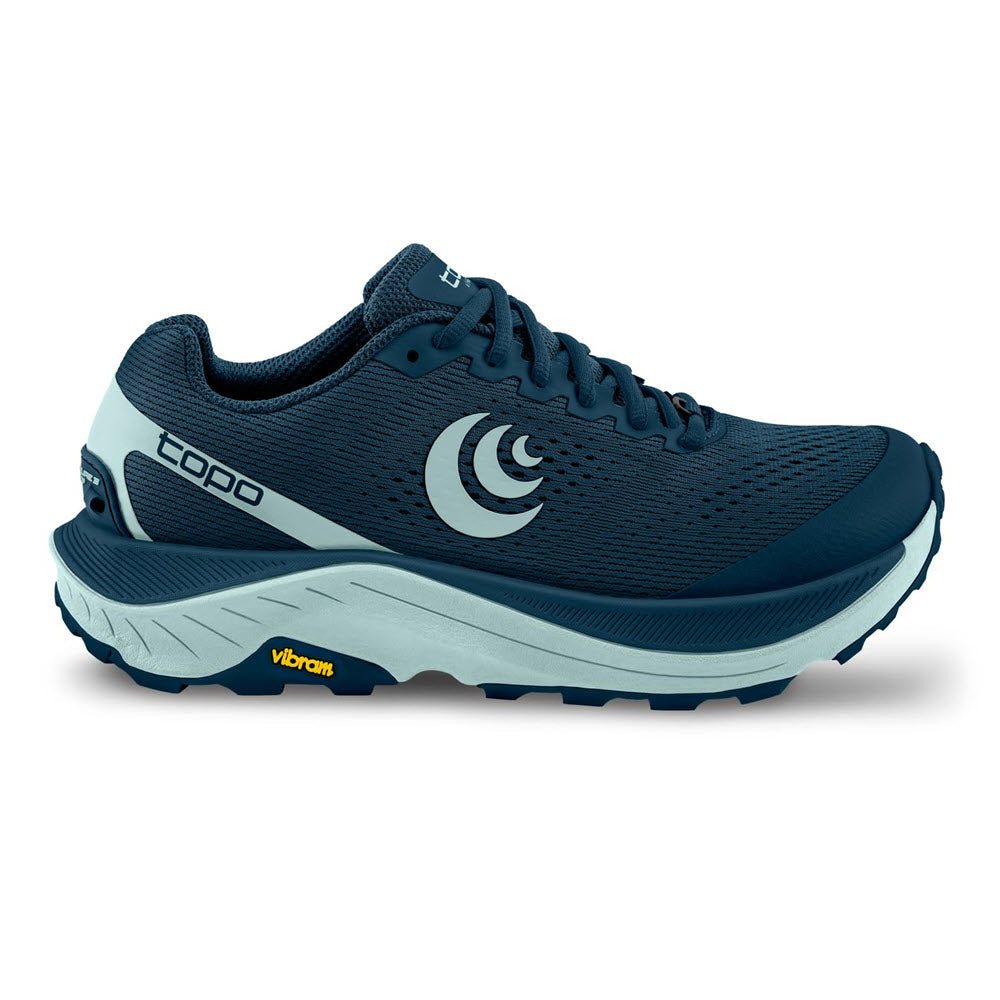 The TOPO UltrAventure 3 Navy/Blue - Women&#39;s is a dark blue athletic shoe with a light blue sole, mesh upper, and laces. It features the brand name &quot;TOPO&quot; on the side and has a yellow Vibram® XS Trek EVO logo on the sole.