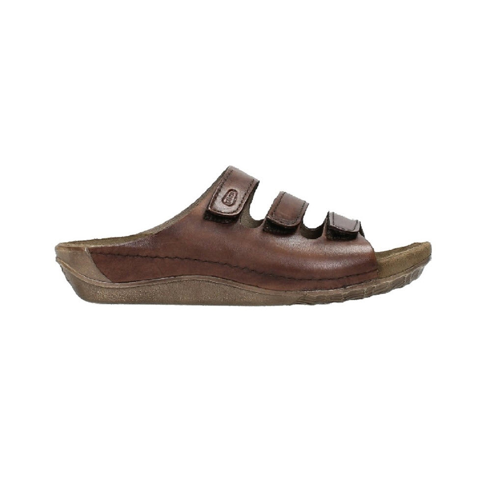 A brown leather WOLKY NOMAD COGNAC - WOMENS with three adjustable Velcro straps and a cushioned memory foam footbed, viewed from the side.