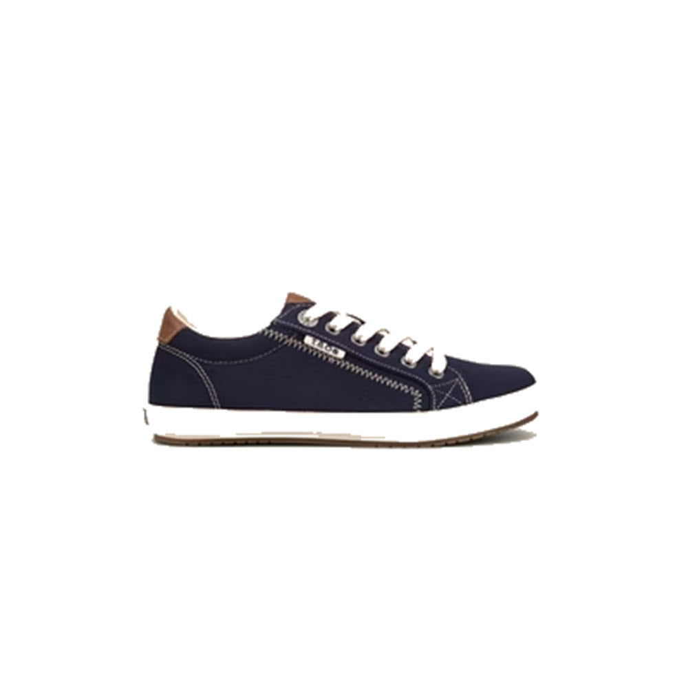 A side view of the Taos Star Burst Navy - Women's casual sneaker in blue, featuring white laces and a white sole against a white background. This sneaker, from Taos, offers a custom fit and showcases contrast stitching along with a brown accent on the heel.