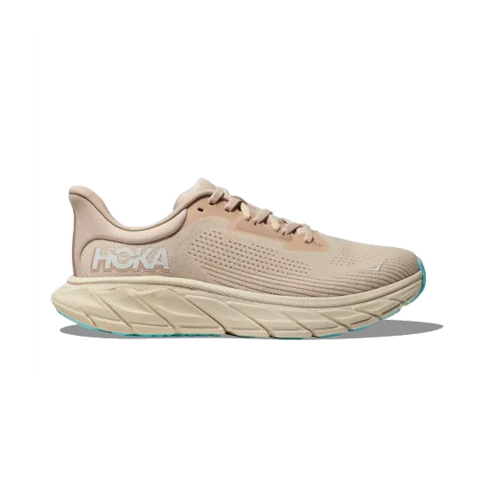 A HOKA ARAHI 7 Women's running shoe in Vanilla/Cream, equipped with a thick CMEVA midsole and light turquoise accents on the sole, featuring innovative J-Frame technology.