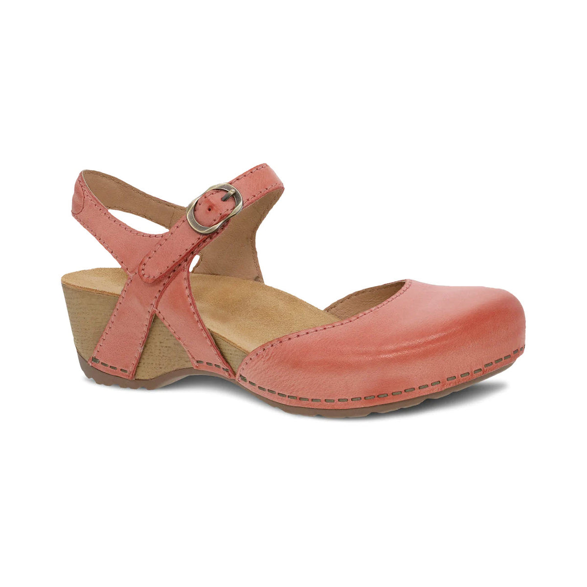 The Dansko TIFFANI Coral - Women&#39;s sandal features a low wedge heel, an ankle strap with buckle closure, and detailed visible stitching around the sole, making it perfect for spring fashion.