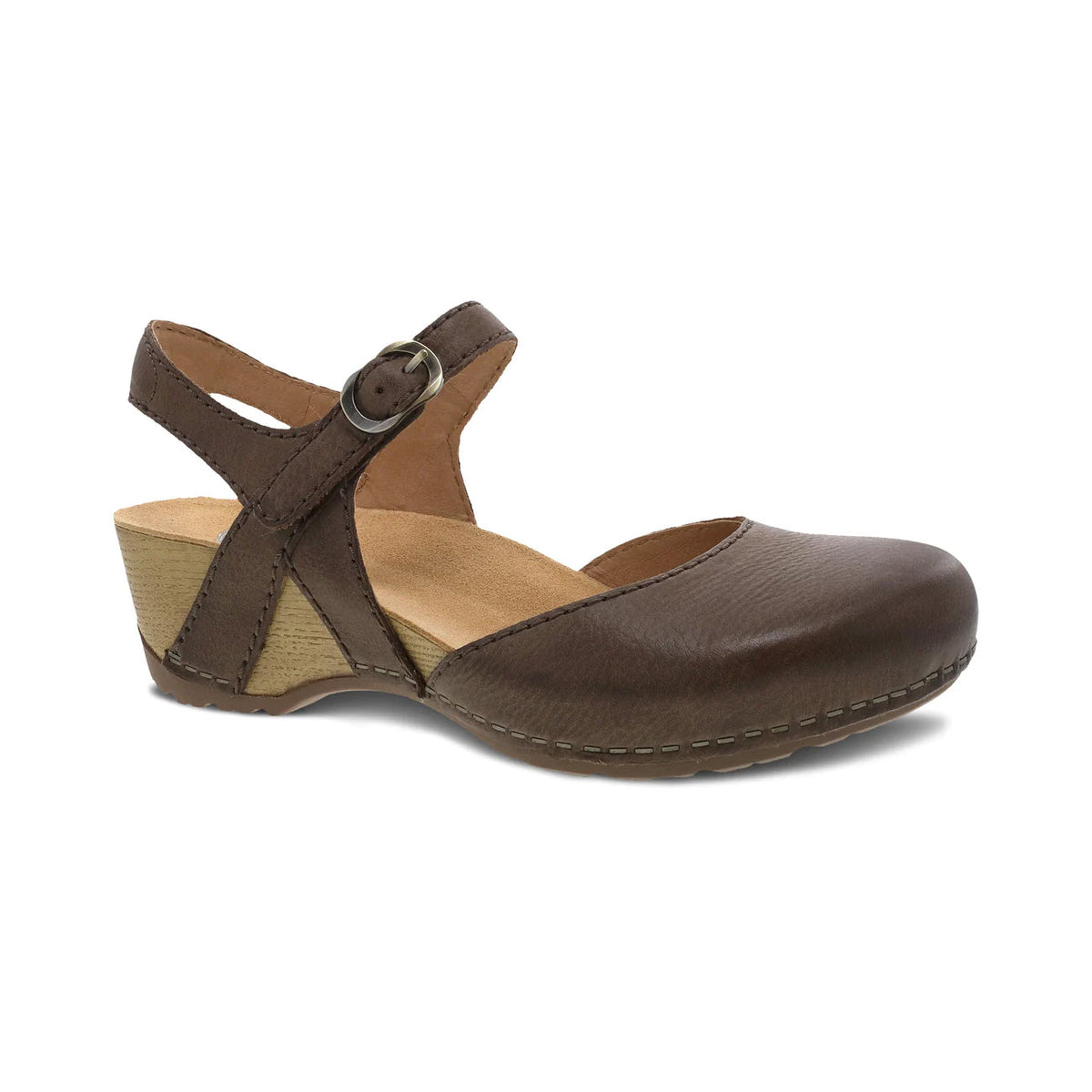 The DANSKO TIFFANI BROWN - WOMENS by Dansko is a brown leather wedge heel shoe with an adjustable ankle strap and buckle, featuring a closed toe and a wooden mid-wedge heel, perfect for spring fashion.