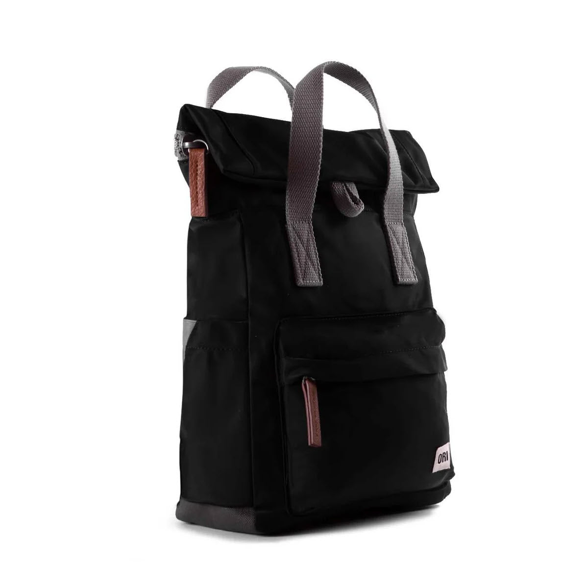 The ORI LONDON CANFIELD B MD BACKPACK BLACK by Ori London is a sleek black travel accessory featuring a roll-top design, dual gray handles, a zippered main compartment, front zip pocket, and small brown accents.