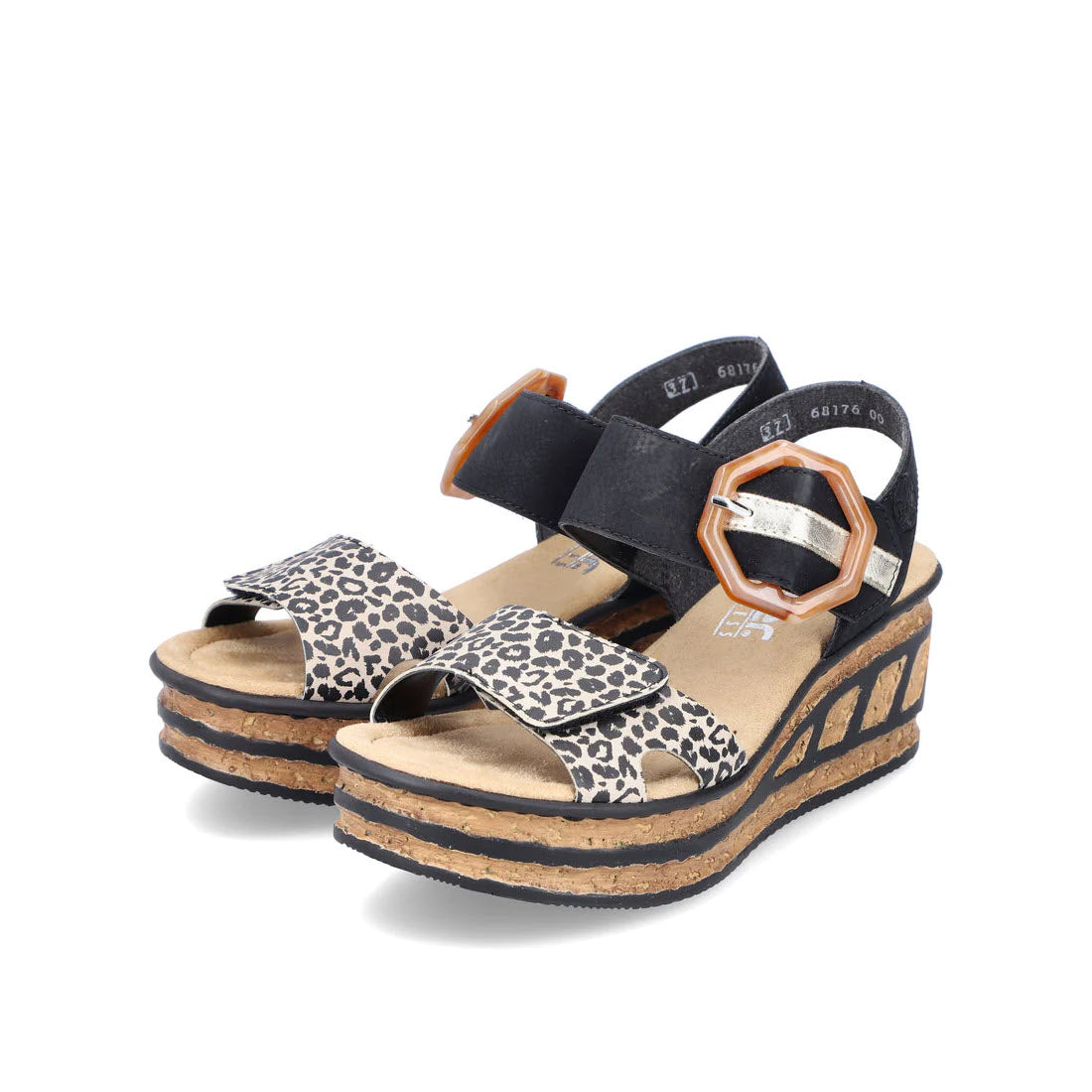 The RIEKER BIG BUCKLE WEDGE LEOPARD MULTI - WOMENS from Rieker features leopard print straps, a black back strap with hexagonal buckles, and a cork platform sole adorned with decorative black lines—perfect for summer holidays.