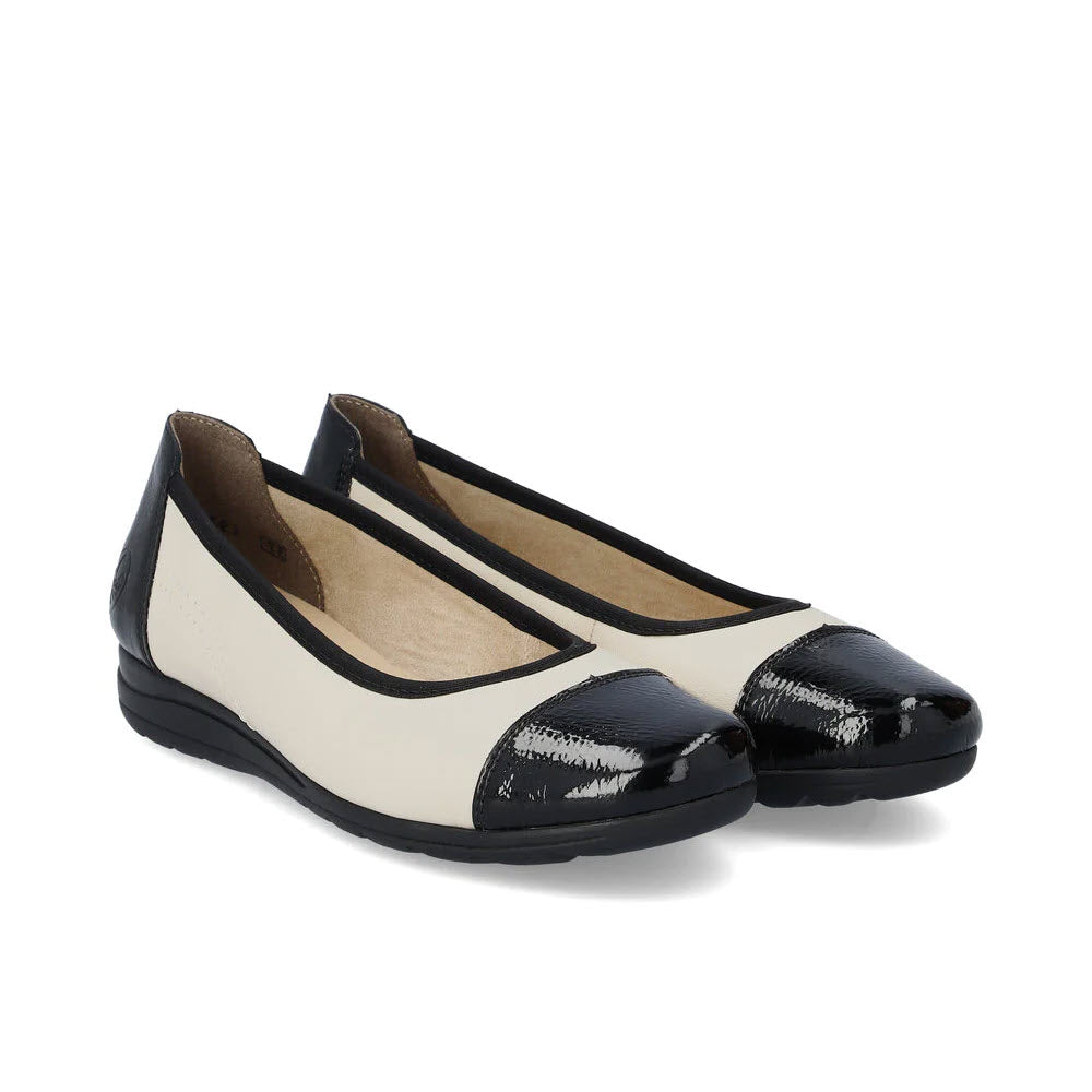 A pair of Rieker women&#39;s ballet flats, named the RIEKER BALLET FLAT BLACK AND TAUPE, showcases white uppers accented by black patent leather toe caps, heels, and trim, finished with comfortable leather insoles.