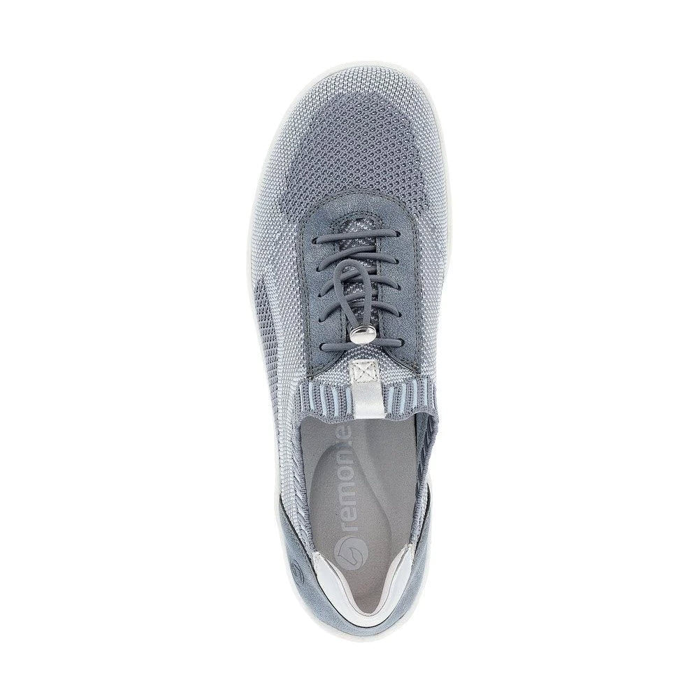 Top view of a single denim-colored athletic walking shoe from Remonte&#39;s REMONTE LITE &amp; SOFT SNEAKER collection for women. Featuring a knitted mesh upper and a slip-on design with a lace toggle, perfect for casual settings.