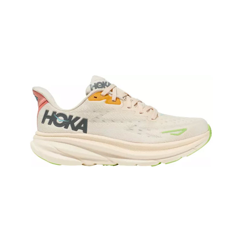 A side view of the vanilla and astral HOKA Clifton 9 running shoe for women showcases a thick, textured sole with green and orange accents, the Hoka logo in large black letters on the side, and a responsive new foam for enhanced comfort. The improved outsole design offers better grip and durability.