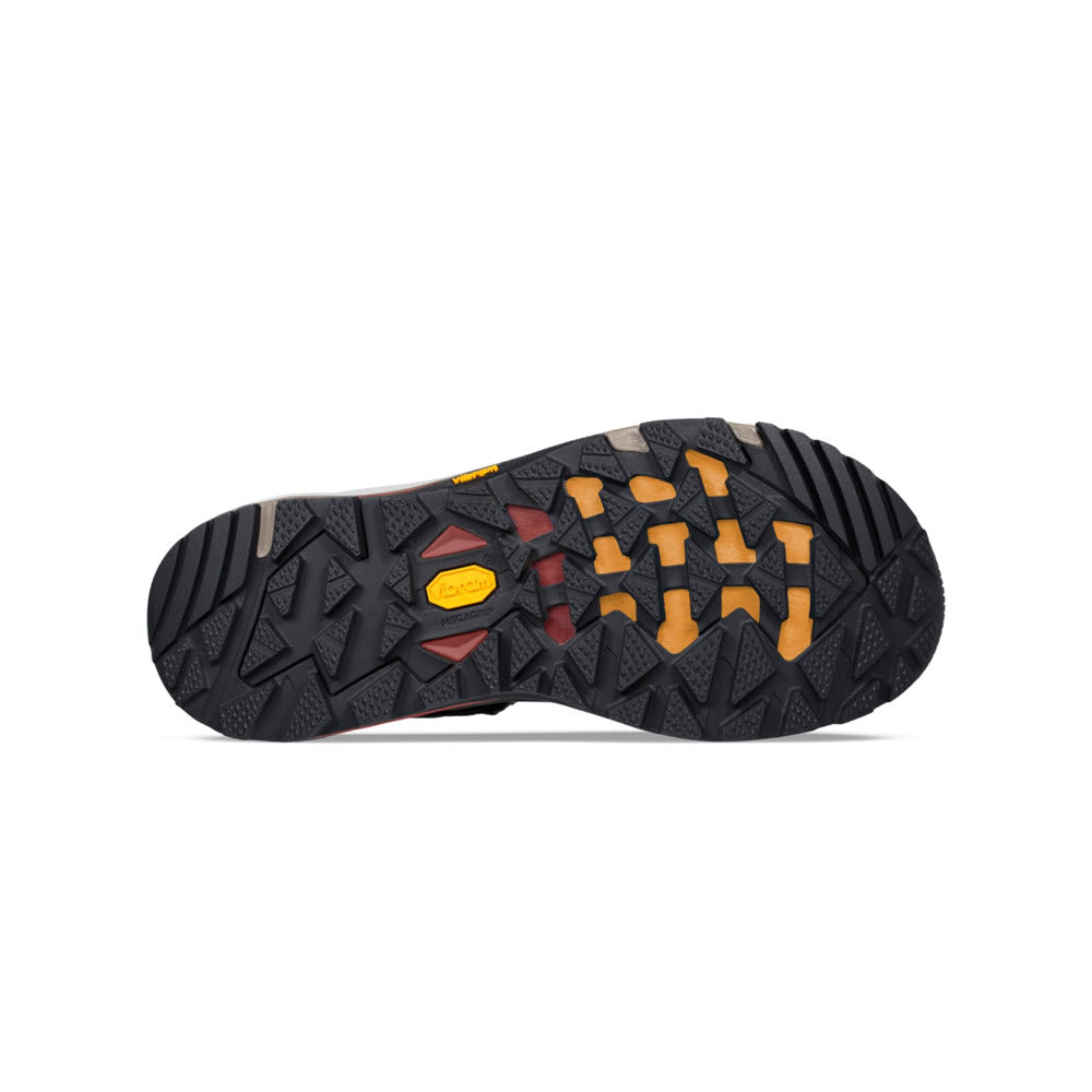 The image shows the sole of an outdoor shoe with a black and yellow rugged tread pattern designed for enhanced traction, featuring a Vibram Megagrip outsole on the Teva TEVA GRANDVIEW GTX DARK OLIVE - MENS.