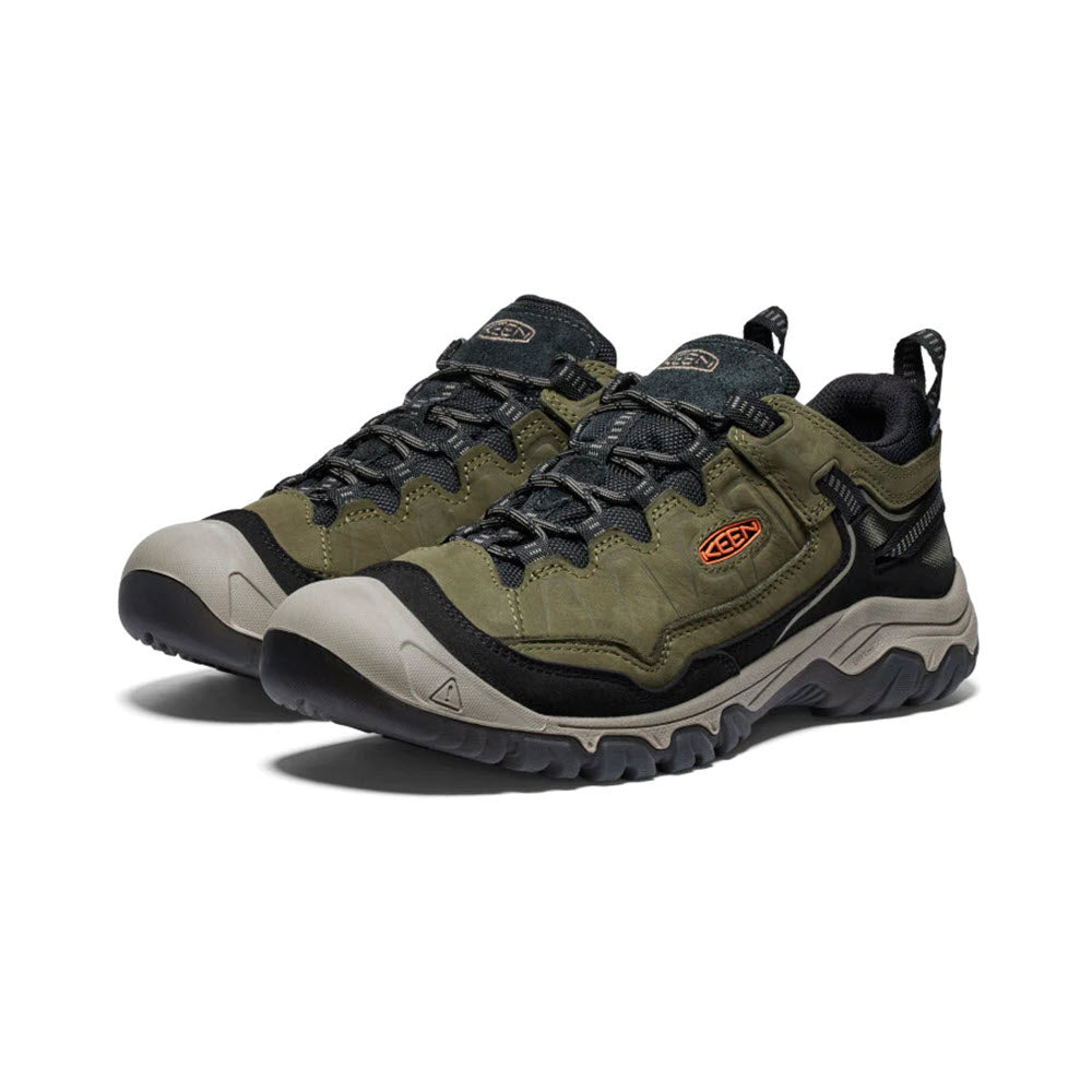 A pair of green and black KEEN TARGHEE IV WP DARK OLIVE/GOLD FLAME - MENS with rugged soles, lace-up closures, and the Keen logo on the side, known for their durable design and superior cushioning.