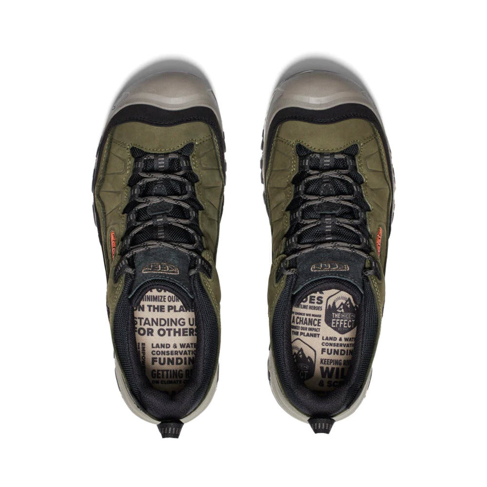 A pair of green and grey KEEN TARGHEE IV WP DARK OLIVE/GOLD FLAME - MENS with black laces viewed from above. The durable insoles feature printed text about conservation and environmental initiatives, offering excellent cushioning for a comfortable journey.