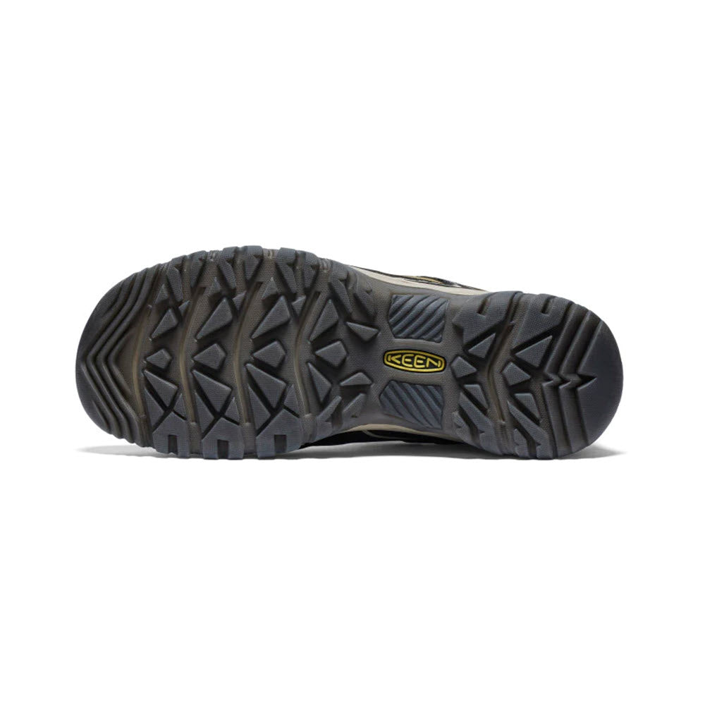 The image showcases the durable sole of a KEEN TARGHEE IV WP DARK OLIVE/GOLD FLAME - MENS shoe, featuring a rugged, textured tread pattern and a yellow &quot;KEEN&quot; logo in the center.