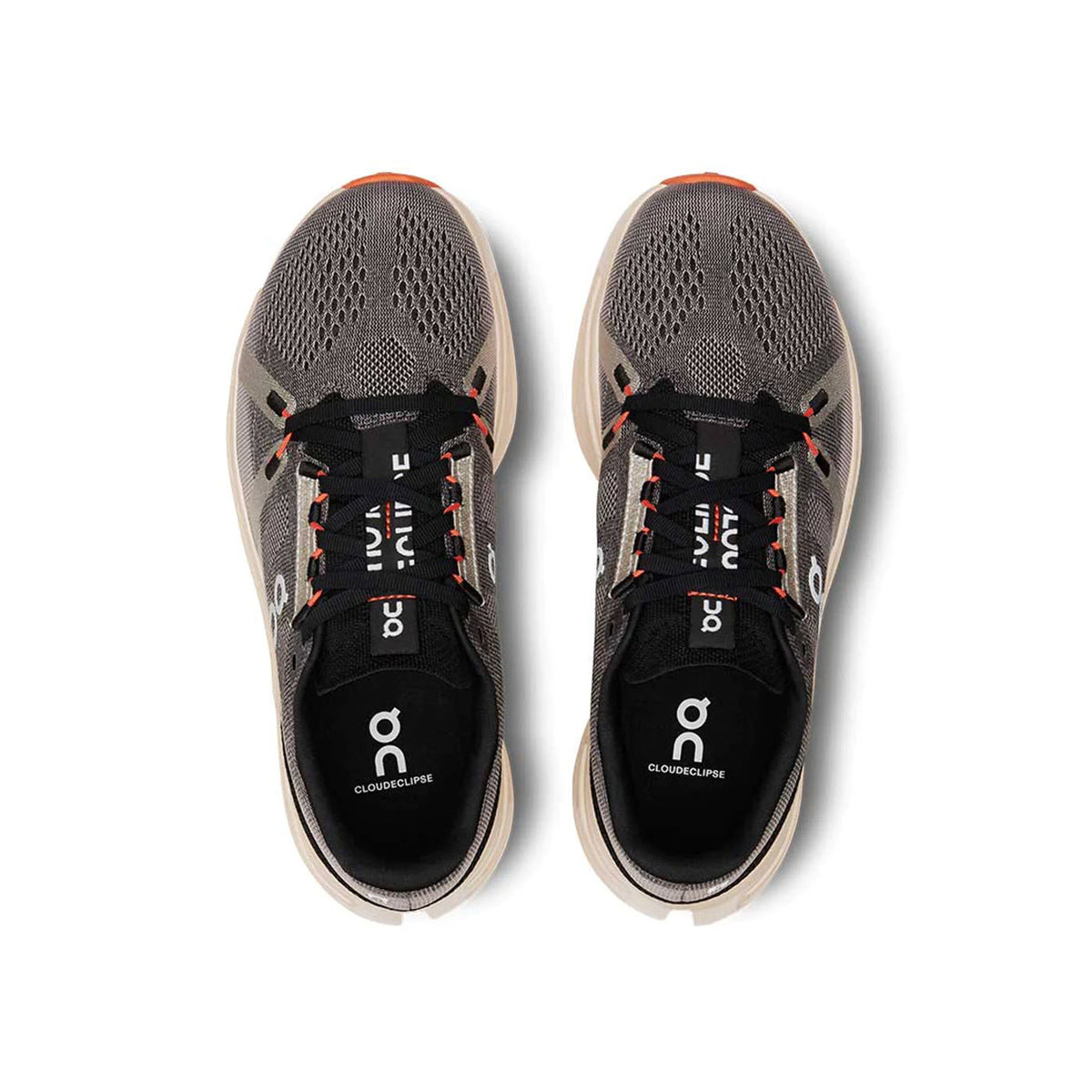 Top-down view of a pair of black and gray running shoes with orange accents, featuring the logo &quot;On&quot; and labeled &quot;Cloudsurfer&quot; on the insoles. These On Running ON CLOUDECLIPSE FADE/SAND - WOMENS shoes boast a CloudTec sole for a cushioned ride and Speedboard construction to enhance your performance.