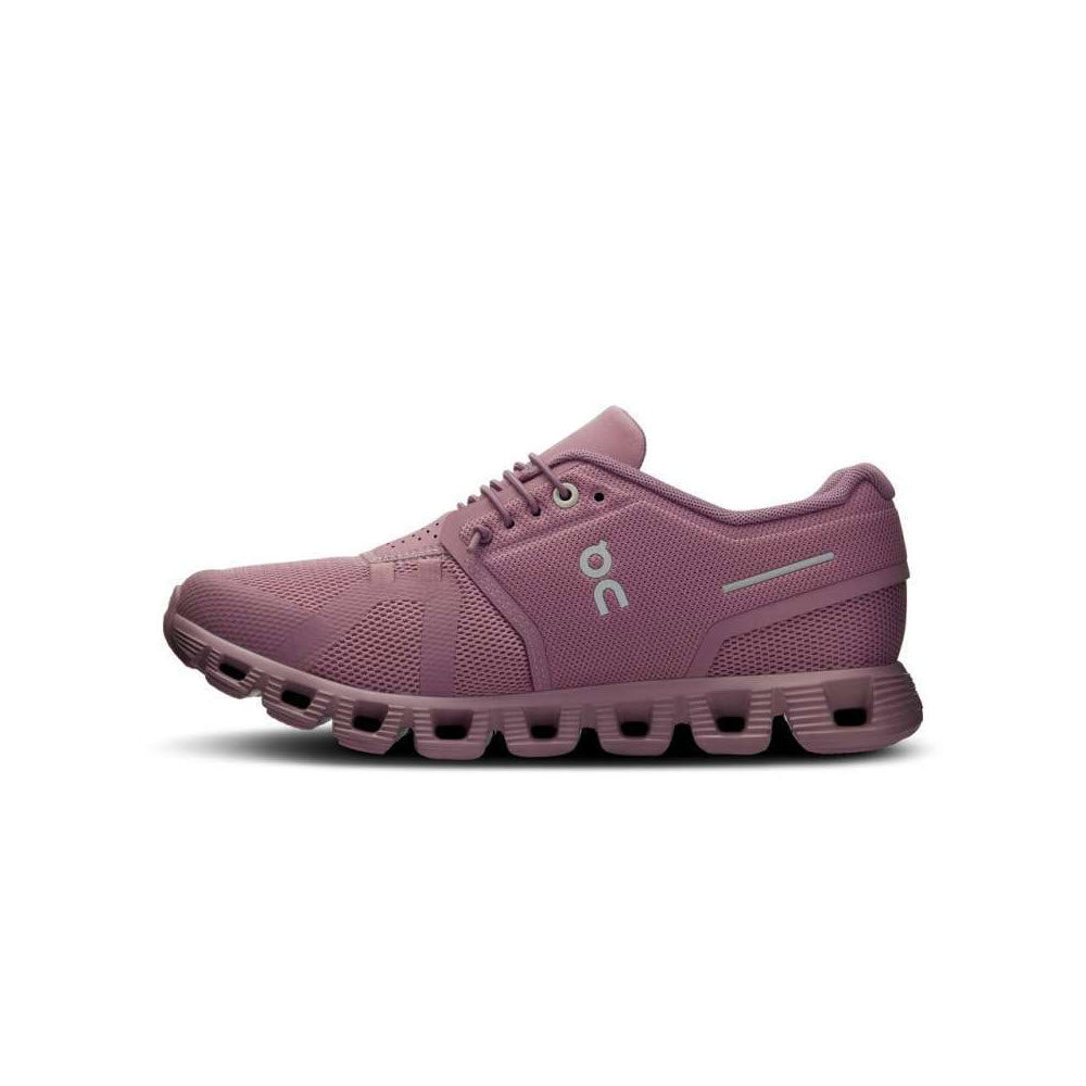 A side view of the ON CLOUD 5 FIG/QUARTZ - WOMEN&#39;S athletic shoe by On Running, featuring a distinctive sole design and the letters &quot;O&quot; and &quot;C&quot; on its side, showcases the CloudTec® in Zero-Gravity foam technology.