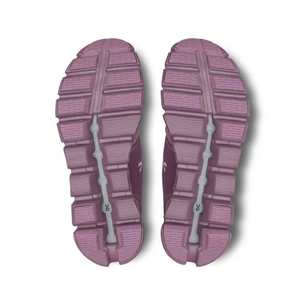 The image shows the soles of a pair of fig/quartz ON CLOUD 5 women&#39;s shoes by On Running, featuring a segmented, flexible design with CloudTec® in Zero-Gravity foam and a gray line running through the middle.