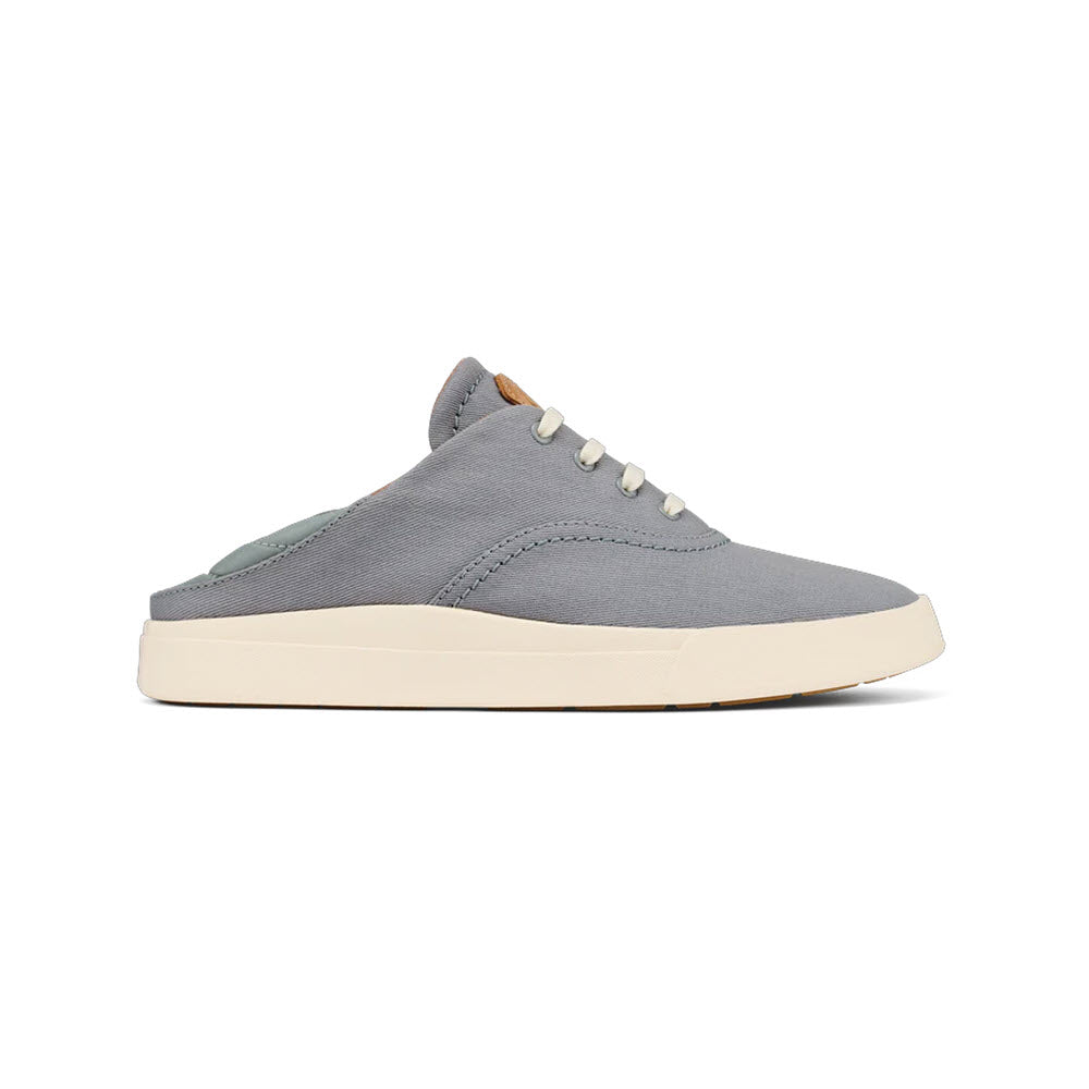 A gray slip-on minimalist sneaker with a white sole, five white eyelets, and cream-colored laces, viewed from the side against a white background. This versatile OLUKAI KOHU MIST GREY - WOMENS shoe epitomizes maximum comfort for any occasion.