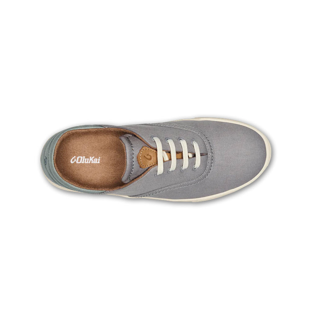 Top view of a versatile Olukai OLUKAI KOHU MIST GREY - WOMENS minimalist sneaker with white laces and a brown insole, showing the brand&#39;s logo.