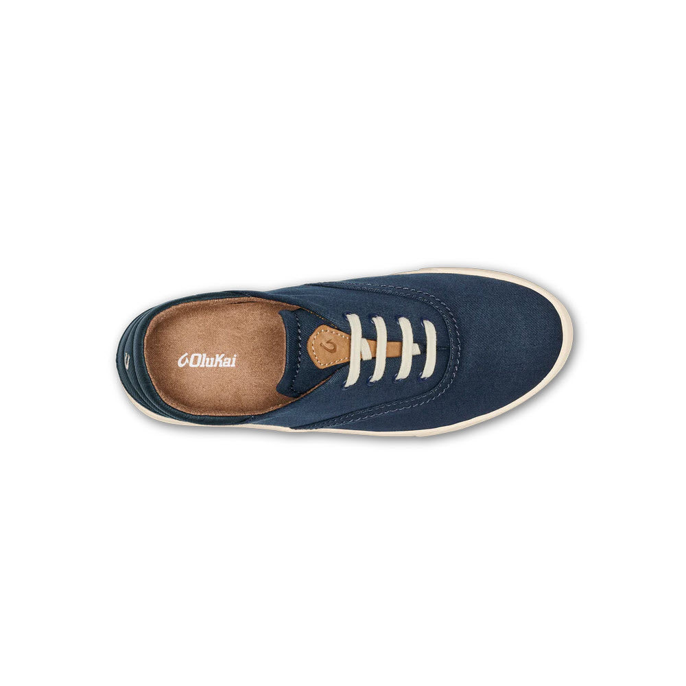 A top view of a blue Olukai OLUKAI KOHU NAVY - WOMENS sneaker with white laces, a beige insole, and a versatile Drop-In Heel against a white background.