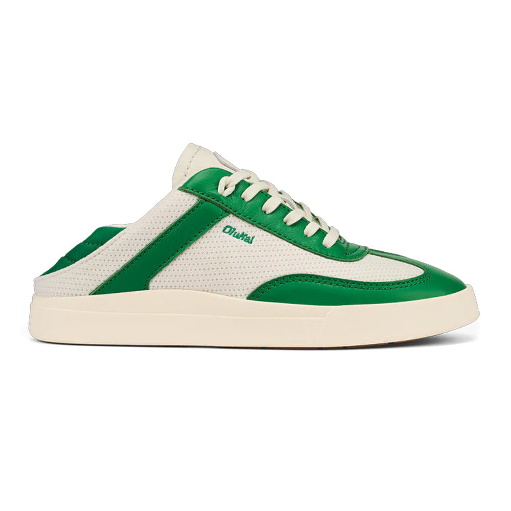 The OLUKAI KILEA OFF WHITE BAMBOO for women is a low-top athletic sneaker designed in a cream and green color scheme, ideal for a beach lifestyle. It features green accents and laces, a white sole, and perforated material for added breathability. Experience cloud-like comfort with the brand name Olukai displayed on the side in green.