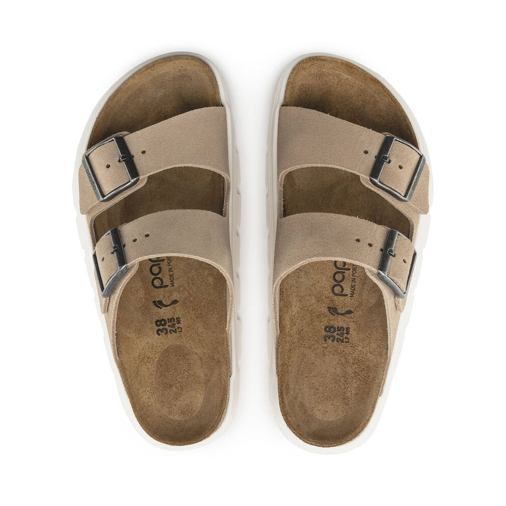 A pair of beige BIRKENSTOCK ARIZONA CHUNKY WARM SAND - WOMENS with two adjustable buckled straps on each, shown from above, featuring a contoured footbed and a chunky platform sole by Birkenstock.