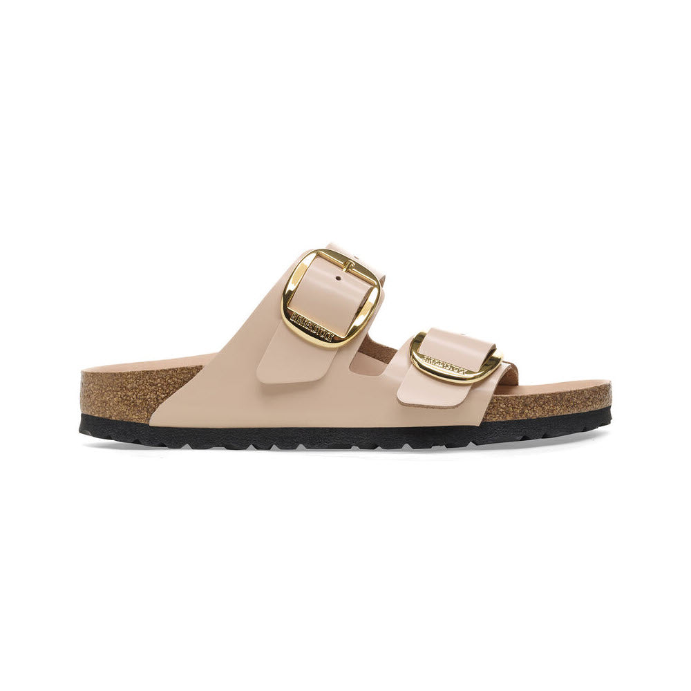 The BIRKENSTOCK Arizona Big Buckle sandal in high shine new beige features two striking gold buckles and is crafted from natural leather. It has a cork sole, black rubber outsole, and a comfortable semi-exquisite footbed.