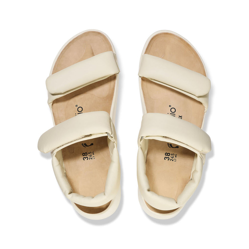 A pair of Birkenstock BIRKENSTOCK THEDA ECRU - WOMENS with padded double straps, a contoured footbed, and cushioned insoles, displayed from a top-down perspective.