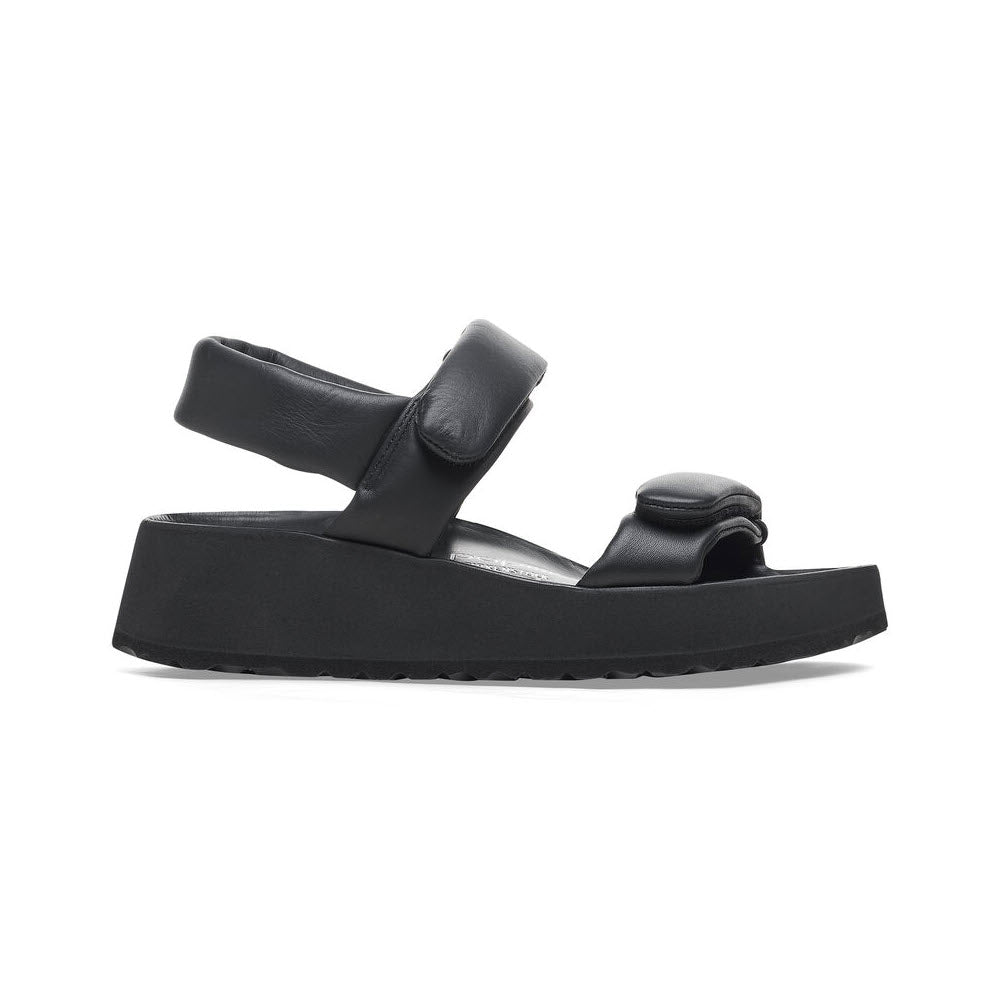 A side view of a black platform sandal, featuring the stylish BIRKENSTOCK THEDA BLACK - WOMENS by Birkenstock, with thick straps, a Velcro closure, and a contoured footbed for added comfort.