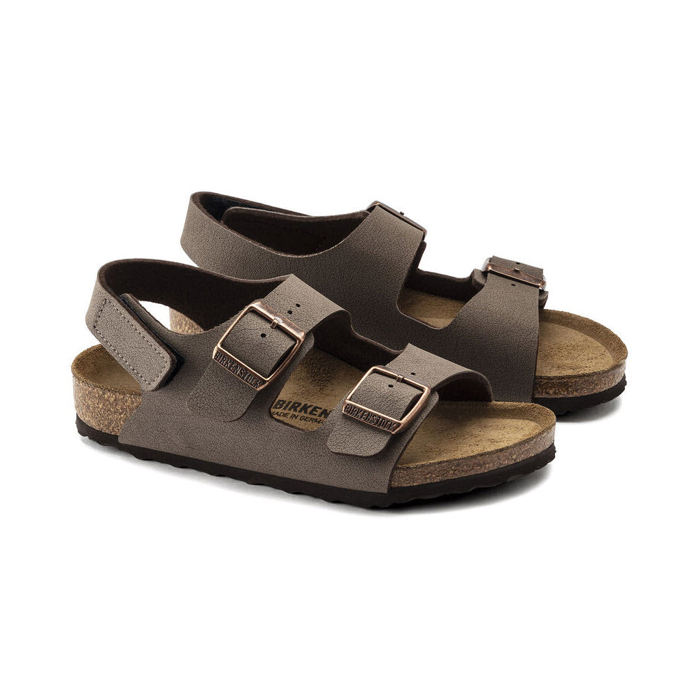 A pair of Birkenstock BIRKENSTOCK MILANO HOOK &amp; LOOP MOCHA BIRKIBUC - KIDS with double adjustable straps and buckles, featuring a cork footbed and contoured sole, perfect for kids&#39; footwear.